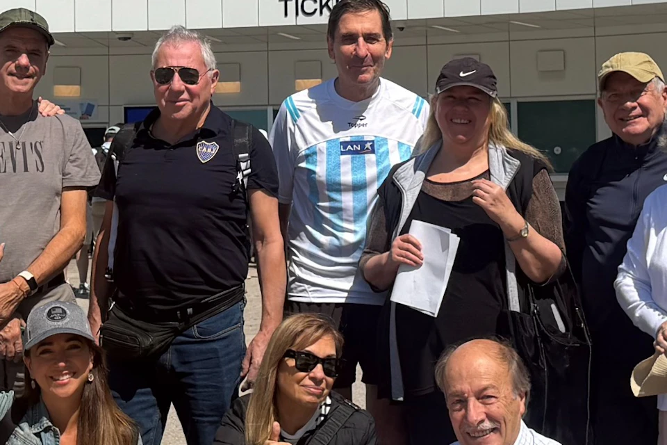 A group of people posing in front of a building with a sign advertising "The Moonwalkers: A Journey with Tom Hanks."