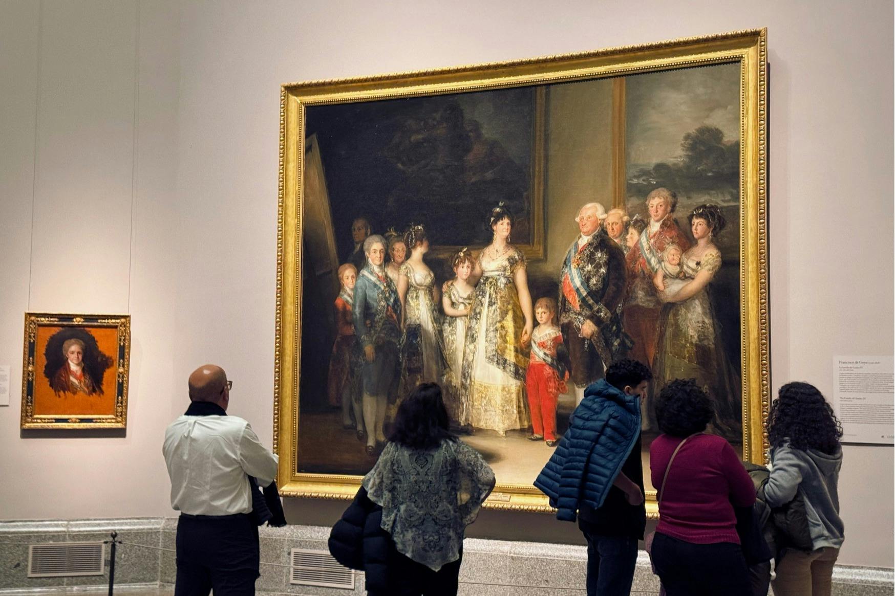 ゴヤのスペイン王室の肖像画の近くに立っているゲスト。