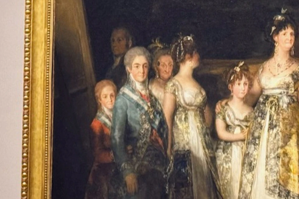 Guests standing close to Goya’s portrait of the Spanish royal family.