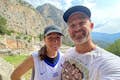 Gäste machen ein Selfie mit der archäologischen Stätte von Delphi im Hintergrund