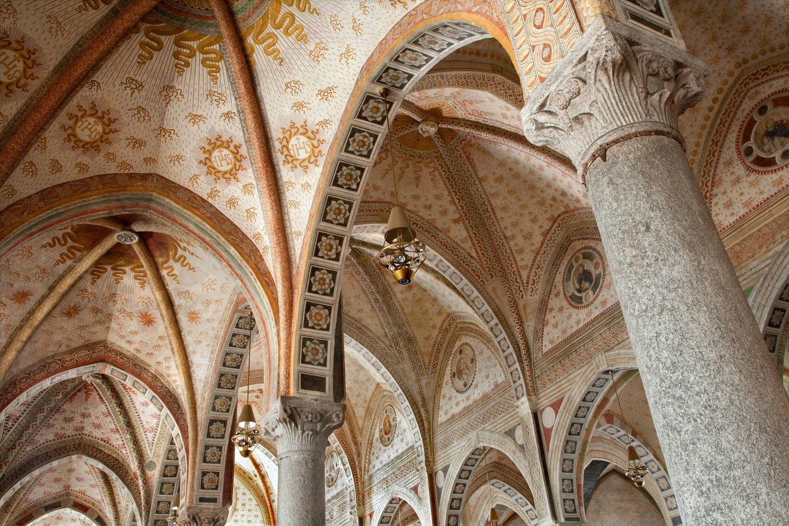 Ornate vaulted ceilings with colorful frescoes and intricate patterns supported by decorated stone columns.