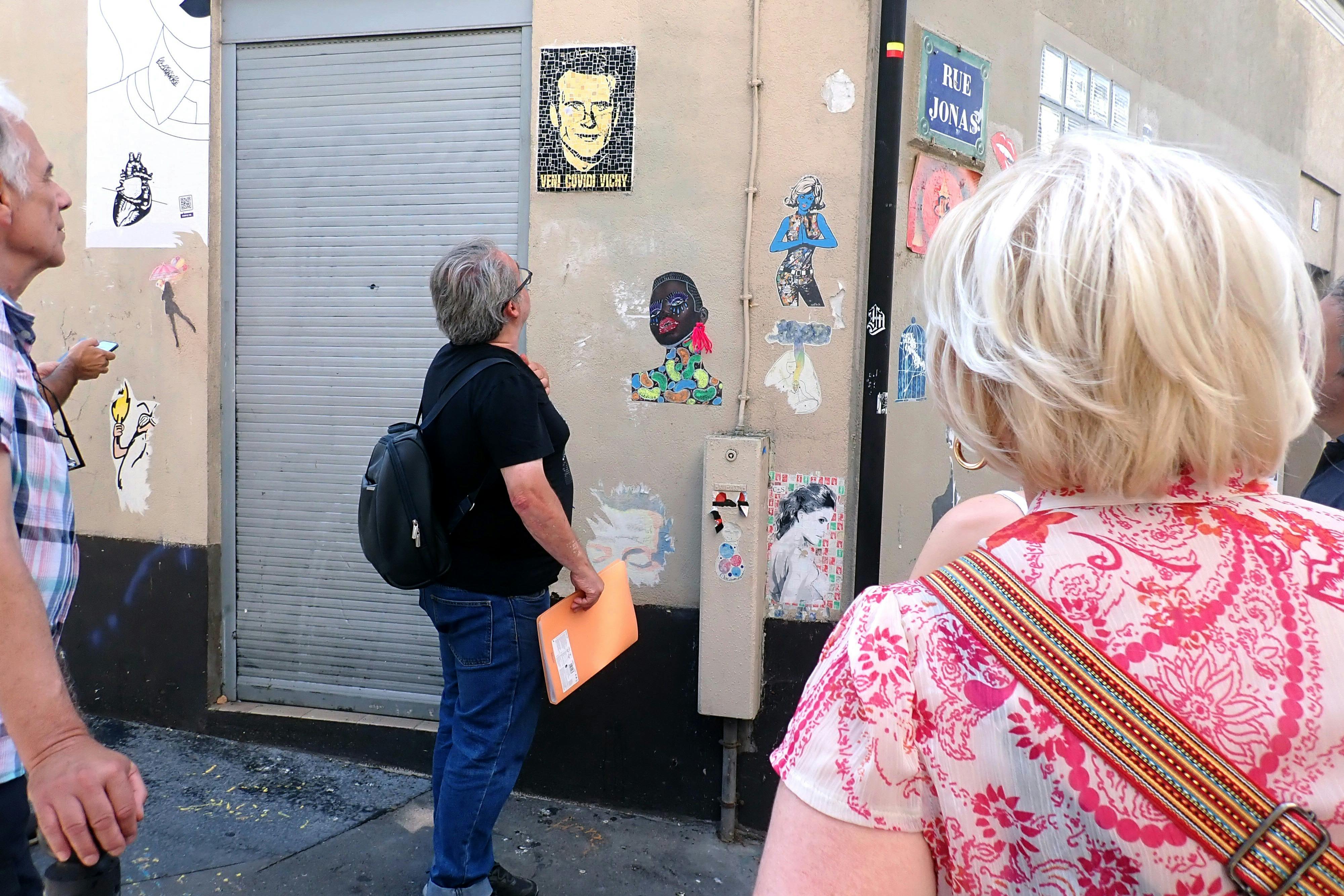 guide and guests looking at street art in the Butte Aux Cailles