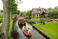 Cruising along the canals in Giethoorn on a small electric boat for a genuine local experience.