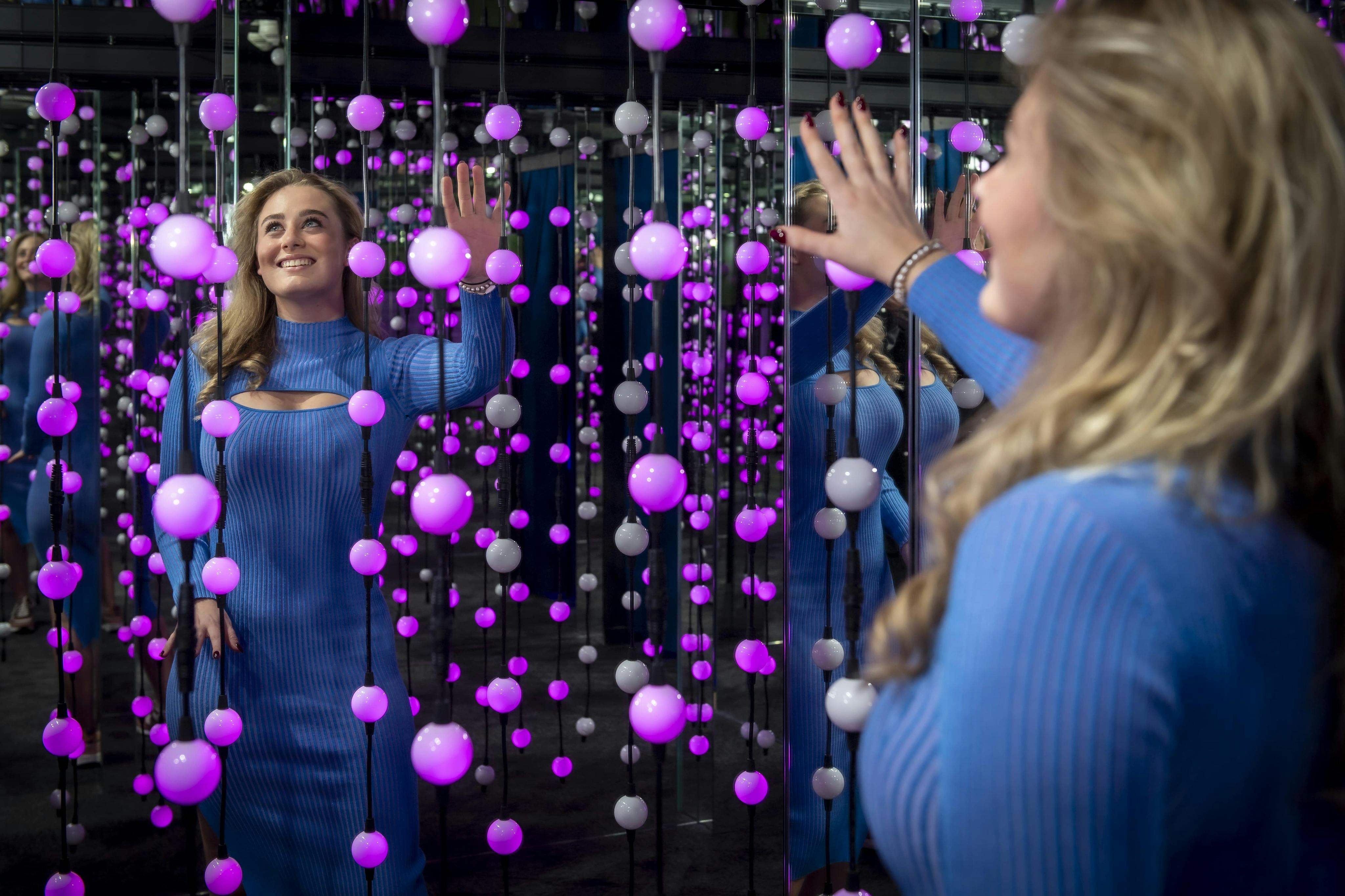 전구가 가득한 조명 방에서 파란색 드레스를 입은 소녀