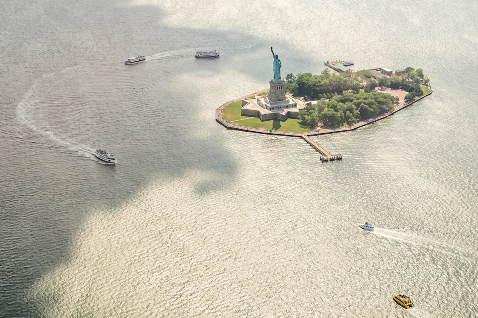 aerial view of ellis island and statue of liberty with ferry boats