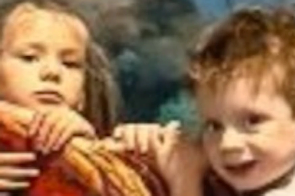 Two children interact with a realistic 3D art display of an octopus and a shipwreck in an underwater-themed setting.
