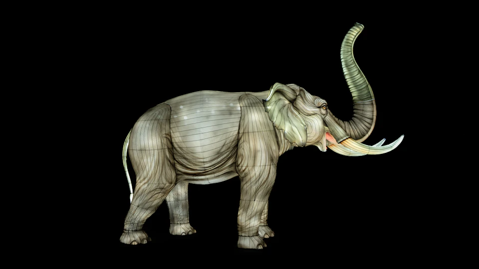 A detailed sculpture of an elephant with its trunk raised, set against a black background.