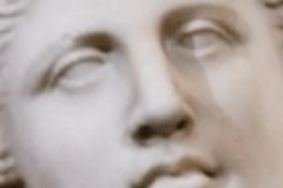 Marble statue of a partially draped, armless woman against a dark marble backdrop.