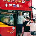 Guests are getting on a red Hop On-Hop Off double-decker sightseeing bus in Copenhagen.
