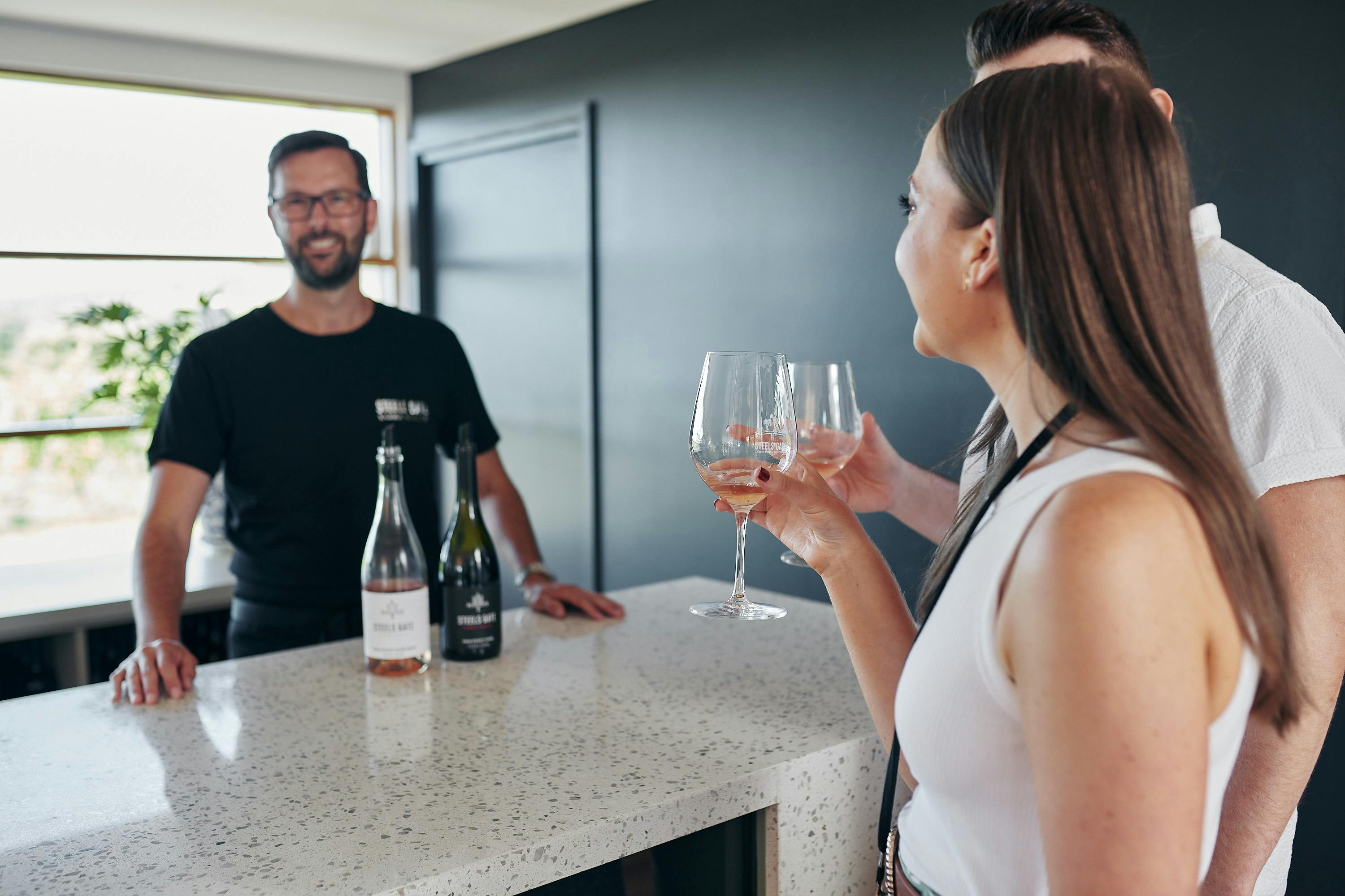 セラーのドアでワインをテイスティングするゲスト