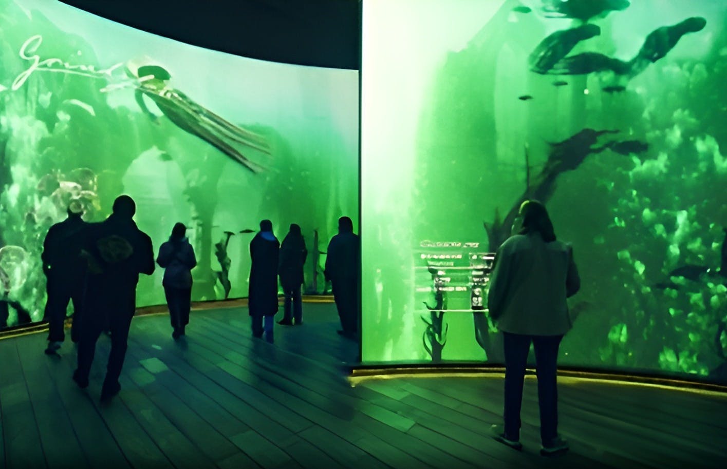 People observing a large aquarium with green-tinted water, giant sea creatures, and informational displays on the glass.