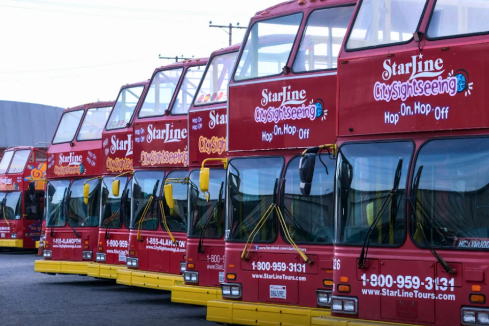 A row of red double-decker sightseeing buses parked in line, displaying "StarLine CitySightseeing" branding.