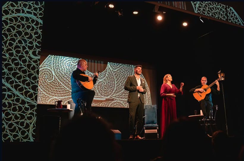 네 명의 뮤지션이 정교한 조명으로 무대에서 공연합니다. 두 개의 기타 연주, 한 명의 남성이 노래하고, 한 명의 여성이 노래하거나 제스처를 취합니다.