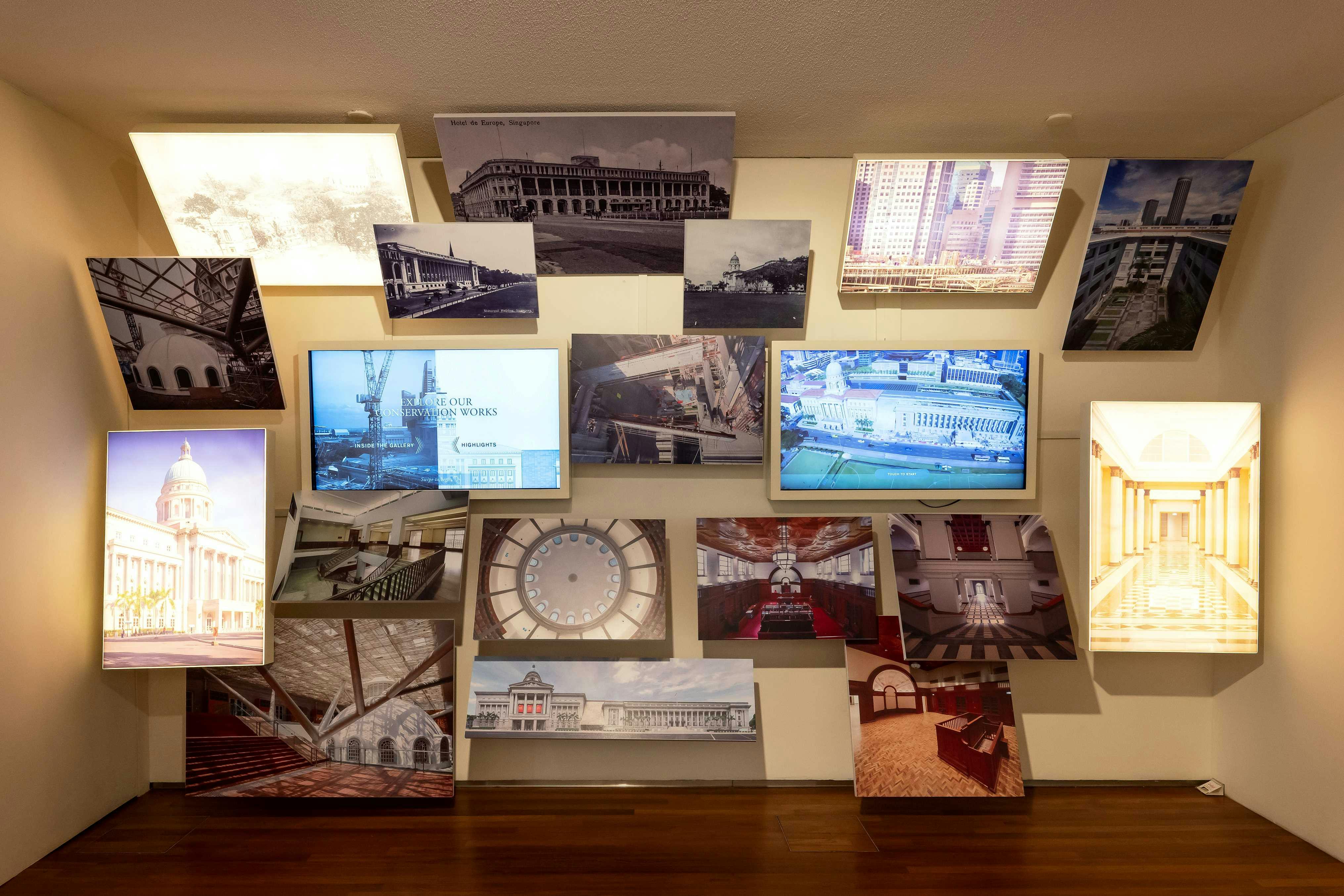 A wall display of various architectural and construction photos, including images of buildings, interiors, cranes, and a clock.