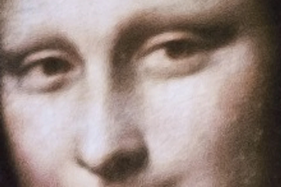 A person holding a tablet displaying the Mona Lisa painting, with other people visible in the blurred background.