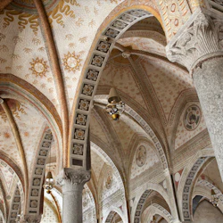 Utsmyckat välvt tak med fresker, invecklade mönster och stenpelare. Hängande lyktor ger belysning.