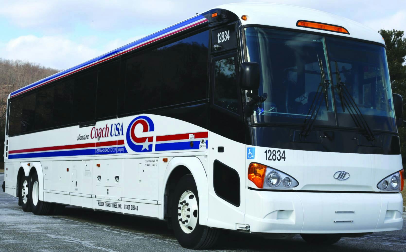 A white Coach USA bus with red and blue stripes, marked with the number 12834, parked on a paved surface.