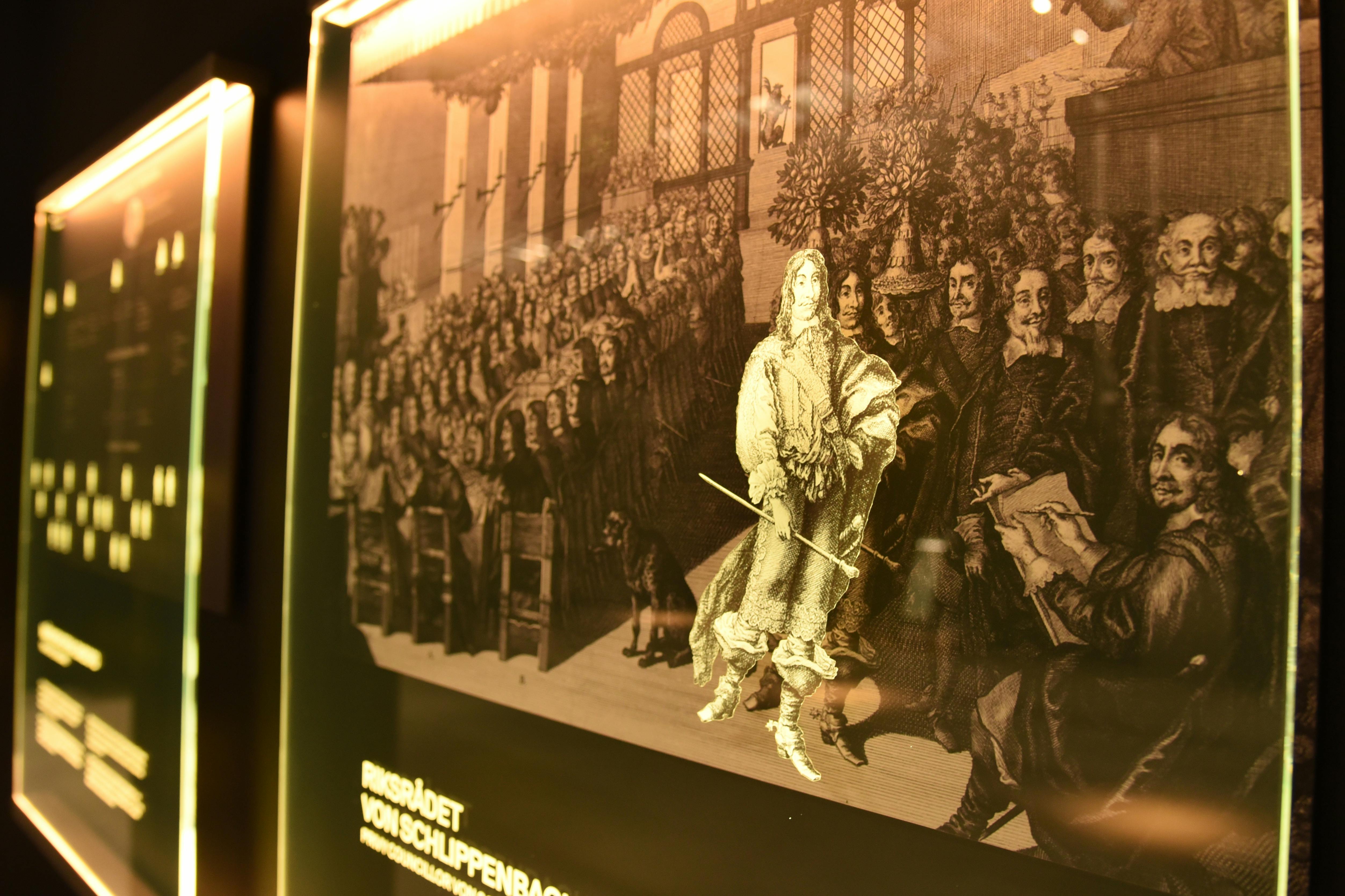 En utställning med upplysta historiska illustrationer av en stor grupp män, märkta "RIKSRÅDET VON SCHLIPPENBACH."