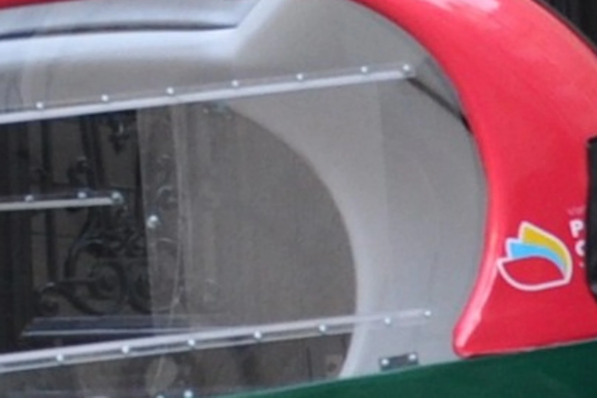 A woman poses near a parked green and red pedicab in front of a building labeled "Patrick Fourtin." The driver sits inside the pedicab.