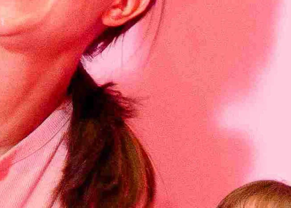 Two people stand inside a room lined with pink refrigerator doors at the Museum of Ice Cream, with a pink and red checkered floor.