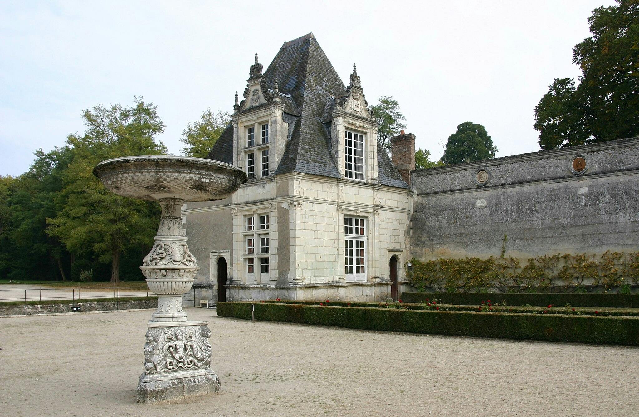 历史悠久的白色石头建筑前有一座华丽的石头喷泉，高高的窗户和陡峭的石板屋顶，周围环绕着花园。