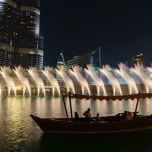 Boot in der Nähe des Burj Khalifa und eine nächtliche Wasserfontänen-Show mit Wolkenkratzern im Hintergrund.
