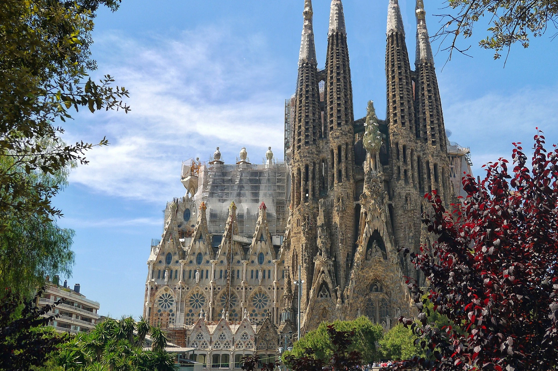A view of the Sagrada Familia basilica in Barcelona, showing its intricate architecture and spires under a clear sky.