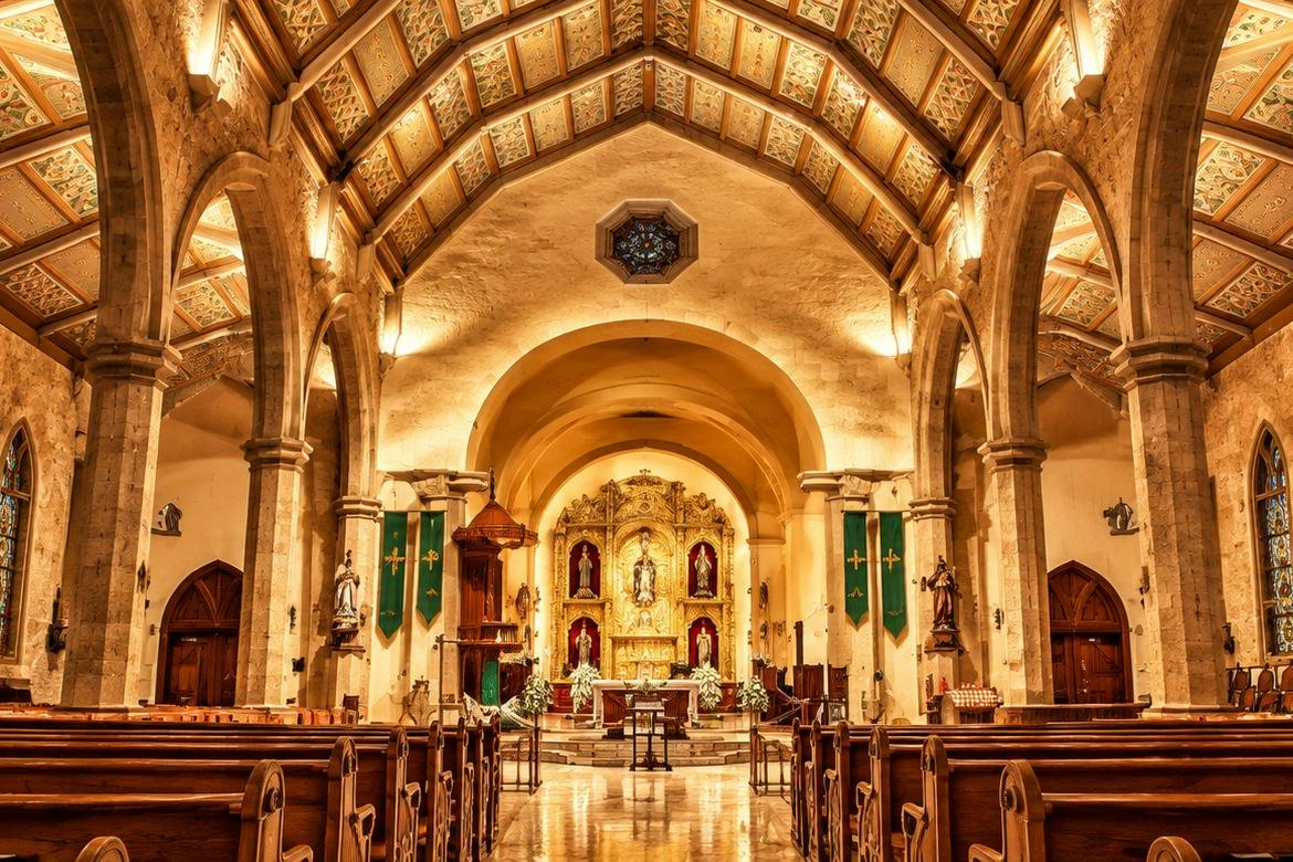 An ornate church interior with arched ceilings, wooden pews, and a golden altar adorned with religious statues and decorations.