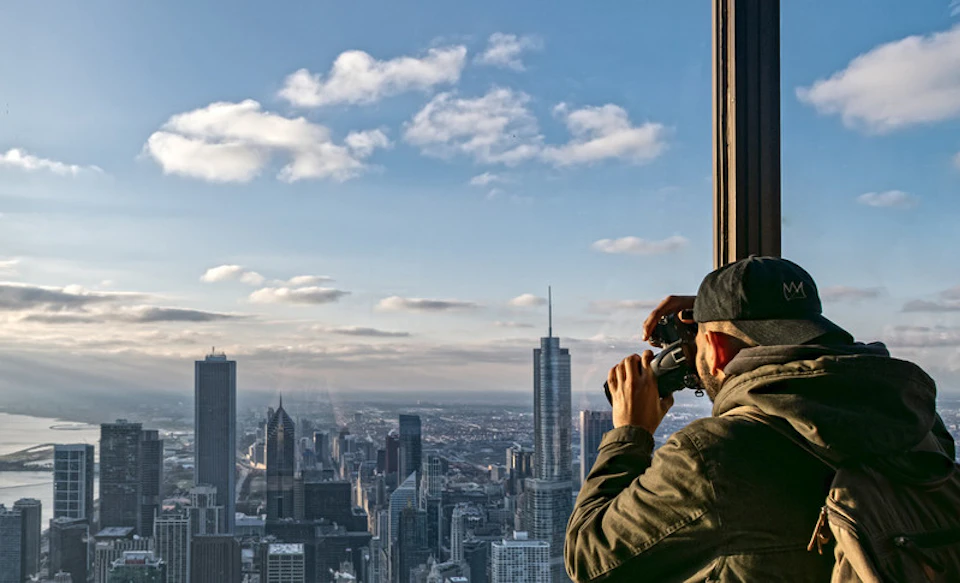 Man taking picture of view of chicago at the top of 360 Chicago observatory