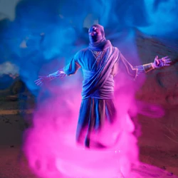 En figur i en mantel omgiven av blå och rosa rök står med utsträckta armar i ett stenigt ökenlandskap.