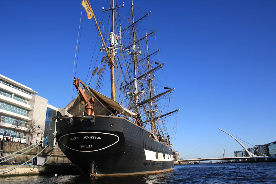 The stern of the Jeanie Johnston famine ship on the River Liffey, with the Samuel Beckett bridge in the background