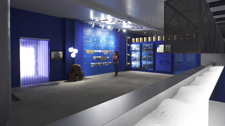 A woman examines a blue wall display with historical photos and text in a modern, well-lit museum exhibit.