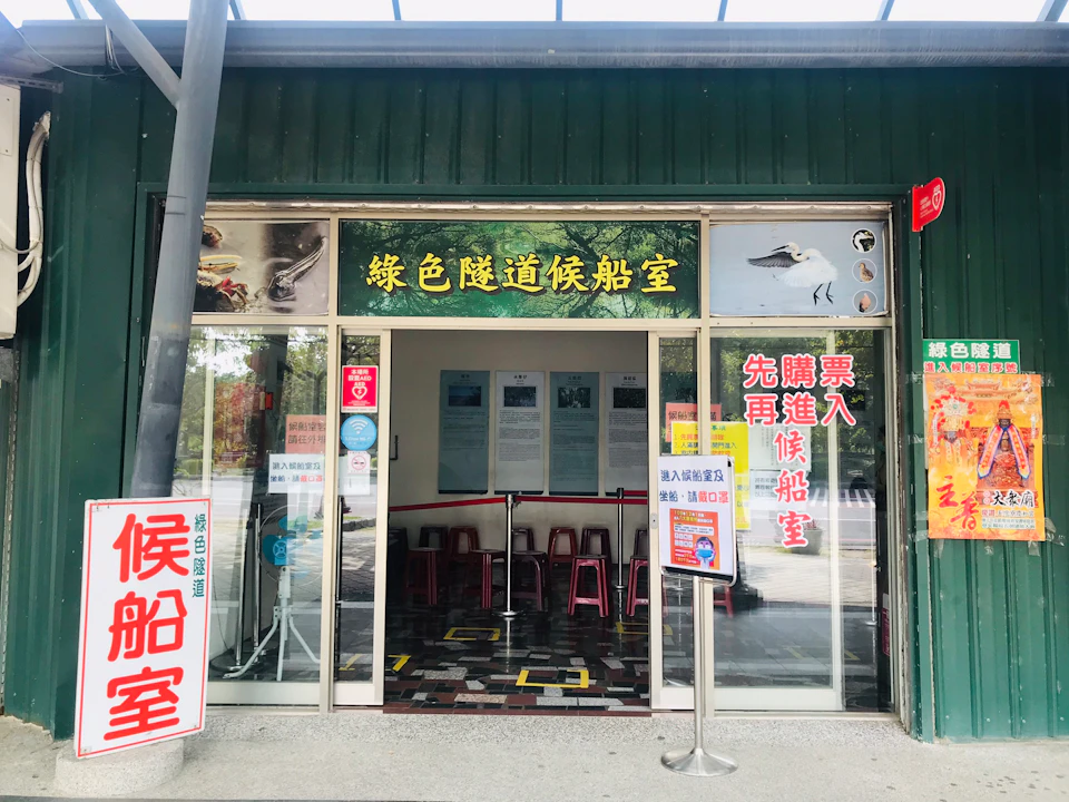 Entrance to a visitor center with glass doors, posters, and signs, featuring nature-themed decorations.