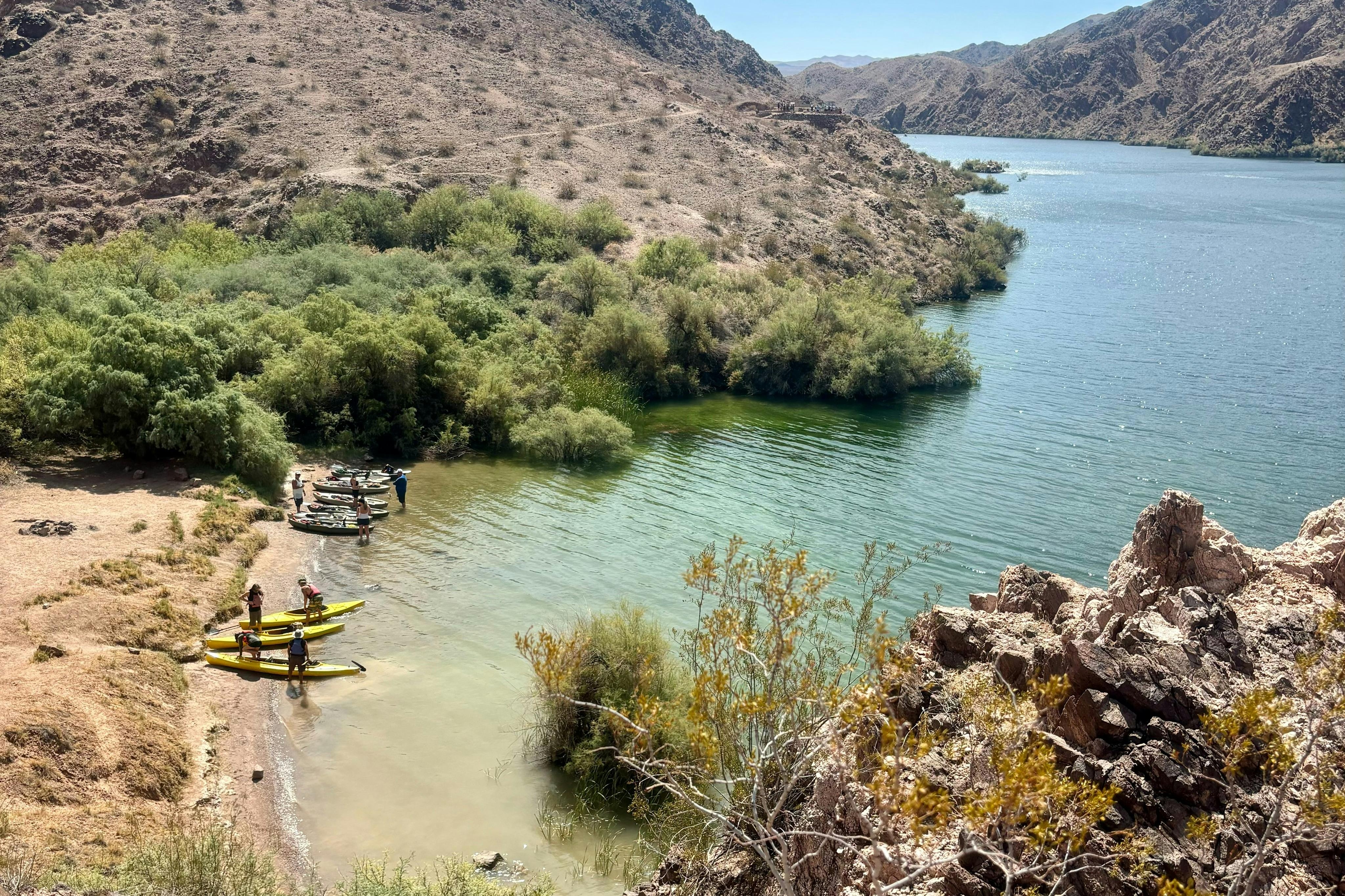 Kayakers stop on the beach to enjoy a quick hike to a historical viewpoint.