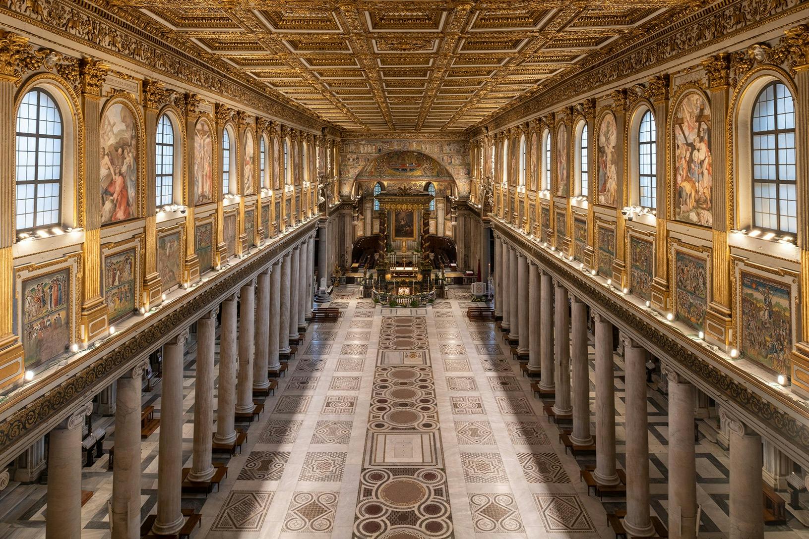 一个装饰着华丽的镀金天花板、高大的柱子和拱形窗户的大厅，通向一个装饰着艺术品的精致祭坛。