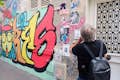 Guía frente a muro con arte callejero