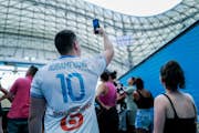 Billede af en besøgende med Aubameyangs trøje, der tager et billede af stadionet.