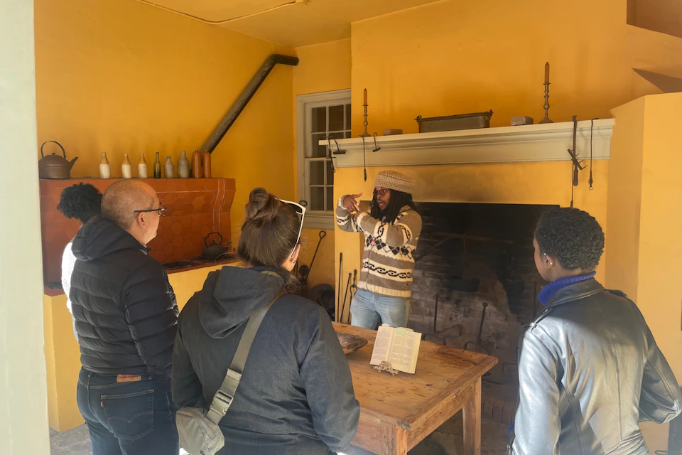 Docent leading a tour of the open-hearth kitchen.