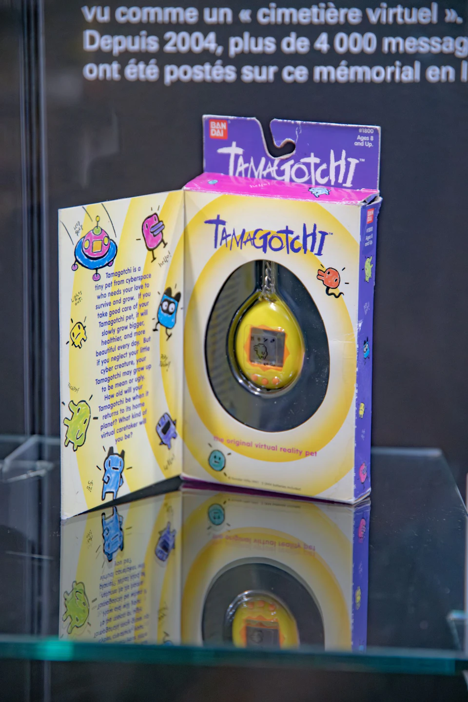 A boxed Tamagotchi, featuring colourful character illustrations and the phrase "The original virtual reality pet", is on display.