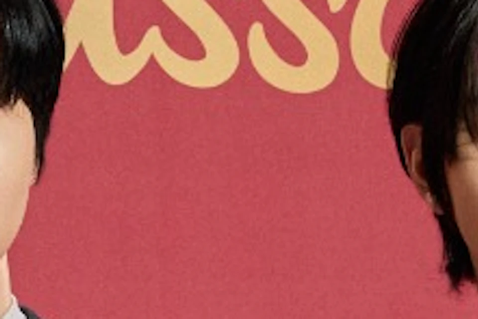 Two individuals in formal suits stand in front of a red backdrop with the text "Madame Tussauds" written on it.