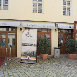 Främre ingången till ett museum för filmens specialeffekter med markiser, en skylt, röda mattan, krukväxter och kullerstensbeläggning.