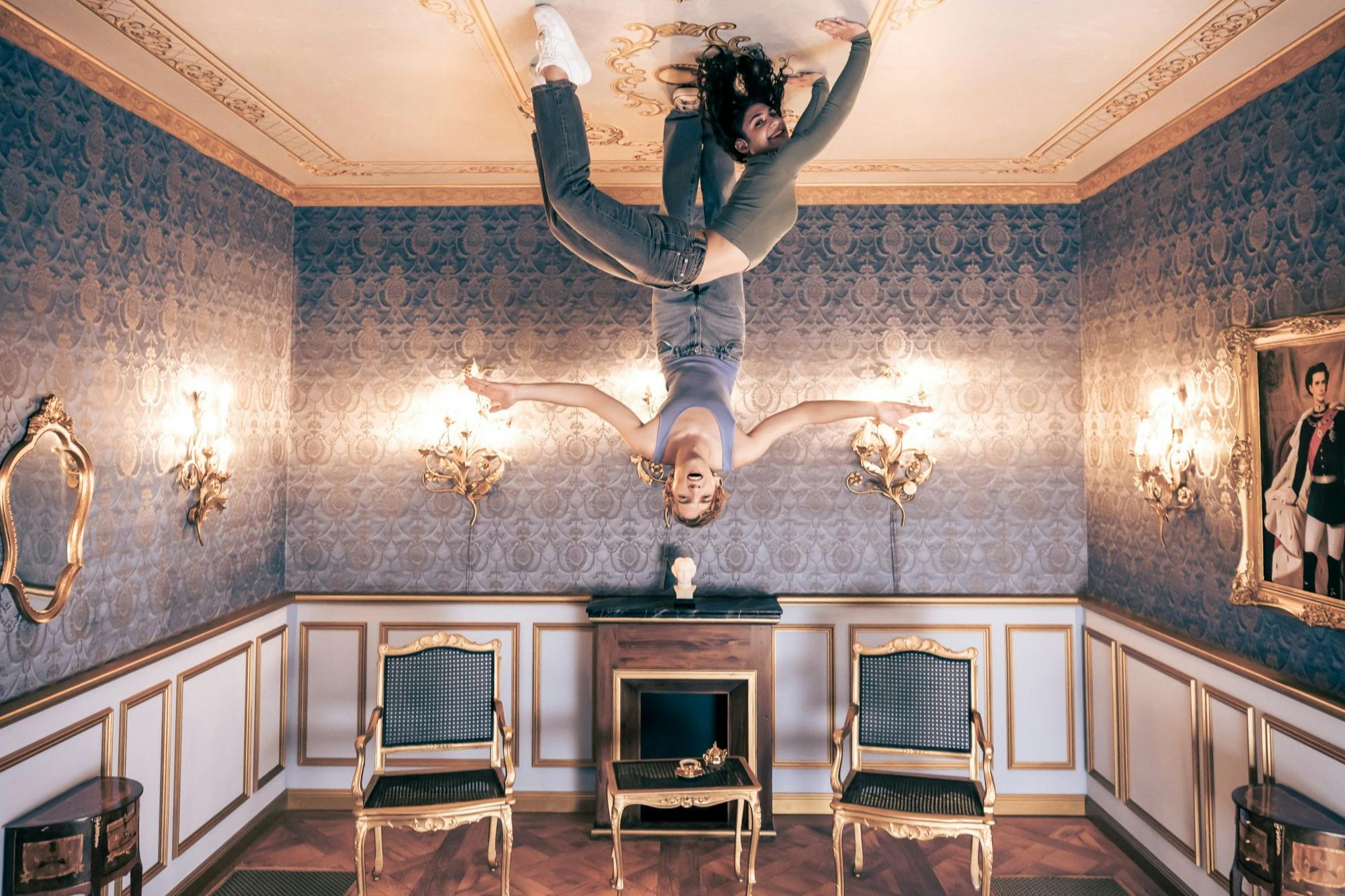 Two visitors appear to hang from the ceiling in the royal hall – a stunning upside-down illusion at Magic Bavaria