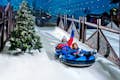 Familjen njuter av att gå nerför en skidbacke på en släde på Ski Dubai