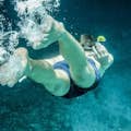 水中の驚異と冒険の精神を体現した、活気に満ちた深海を探検するシュノーケリング選手の魅力的な写真。