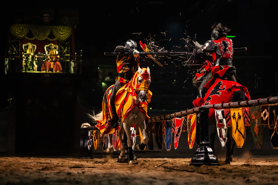 Two knights on horseback jousting in an arena, each wearing colorful armor and holding lances, with an audience watching.