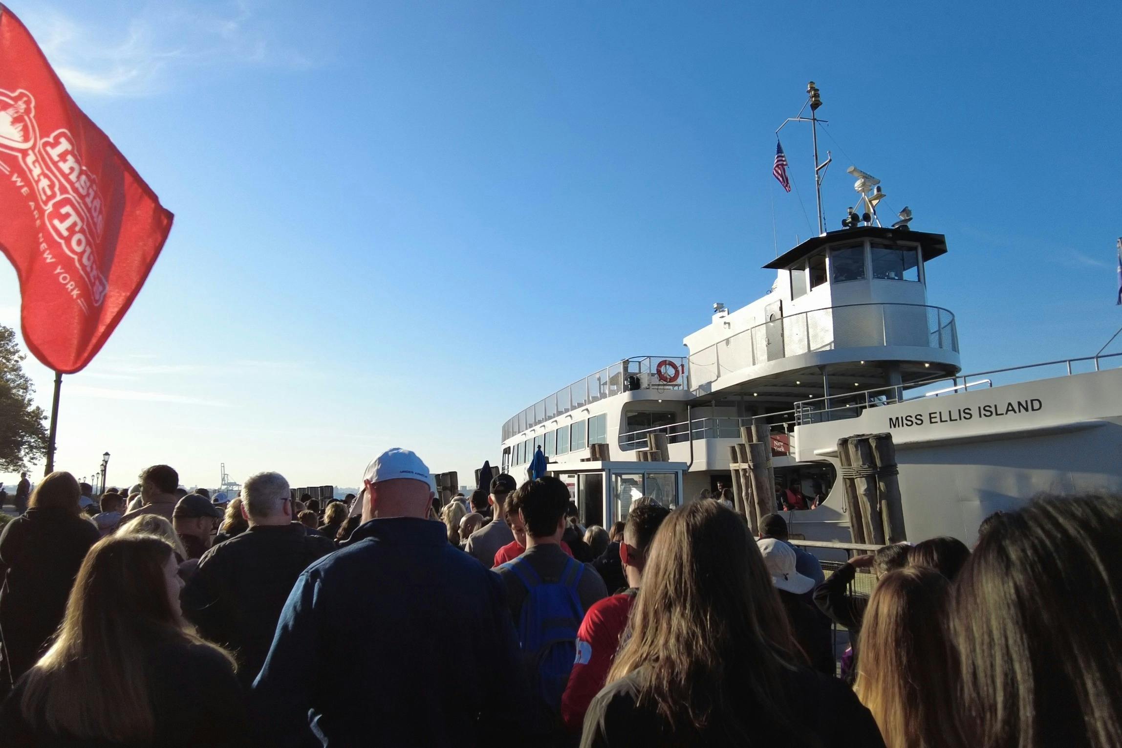 Tętniące życiem zdjęcie naszej grupy wycieczkowej przed promem Statua Wolności, gotowej na niezapomnianą podróż.