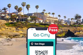 San Diego All-Inclusive Pass da Go City exibido em um smartphone com uma praia de San Diego ao fundo