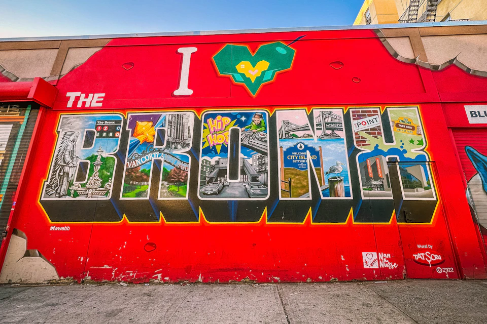 A vibrant mural with the text "I ❤️ THE BRONX" featuring various landmarks and cultural elements within each letter.