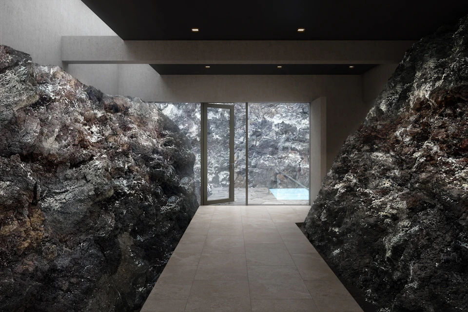 Interior hallway with rocky walls, a tiled floor, and a glass door leading to an outdoor area with a small pool.