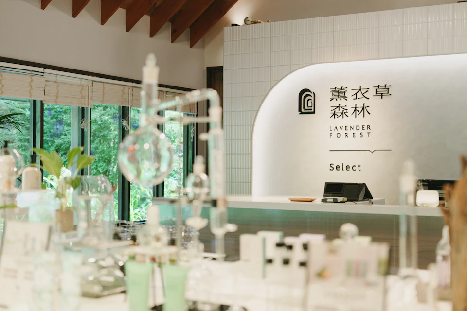 A modern interior with a counter displaying laboratory glassware and a sign reading 'Lavender Forest Select' on the wall.